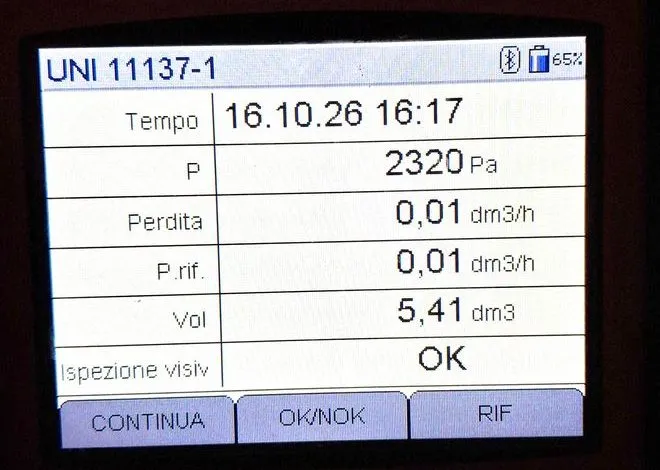 Display dello strumento per la prova di tenuta gas nella seconda centrale: pressione 2320 Pa, perdita 0,01 dm³/h, ispezione visiva OK
