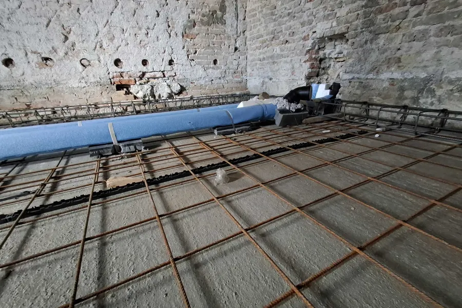 Tubazione di scarico con guaina blu fonoisolante fissata sopra la rete elettrosaldata, prima del getto